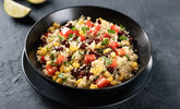 L'image montre un plat coloré et appétissant de quinoa mélangé à une variété de légumes.