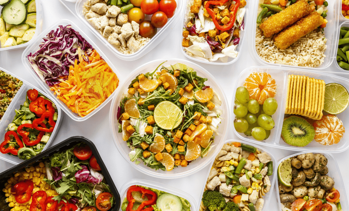 Cette image montre une variété de repas préparés à l'avance, rangés dans des récipients hermétiques. Chaque plat semble soigneusement équilibré avec une combinaison de protéines, légumes, fruits et glucides.