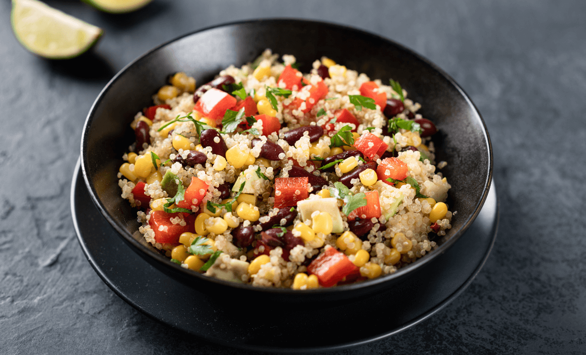 L'image montre un plat coloré et appétissant de quinoa mélangé à une variété de légumes. 