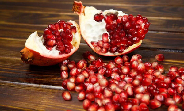 Ein saftiger, halbierter Granatapfel mit seinen roten Kernen und innen saftig