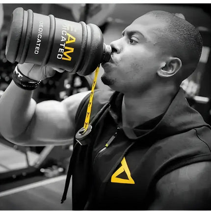 Athlète musculation buvant dans la Dedicated Waterjug – gourde sport 2,2 L Team Dedicated